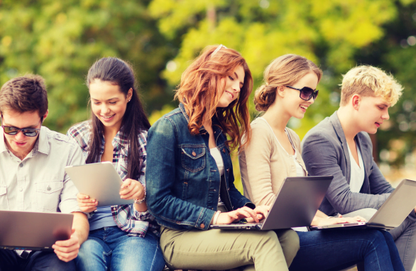 A Group Of People Sitting On A Bench With Laptops And Tablet Computers A group of people sitting on a bench with laptops and tablet computers