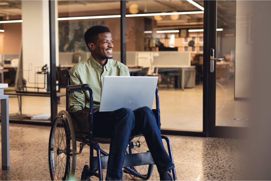 Disabled man smiling while working on his laptop